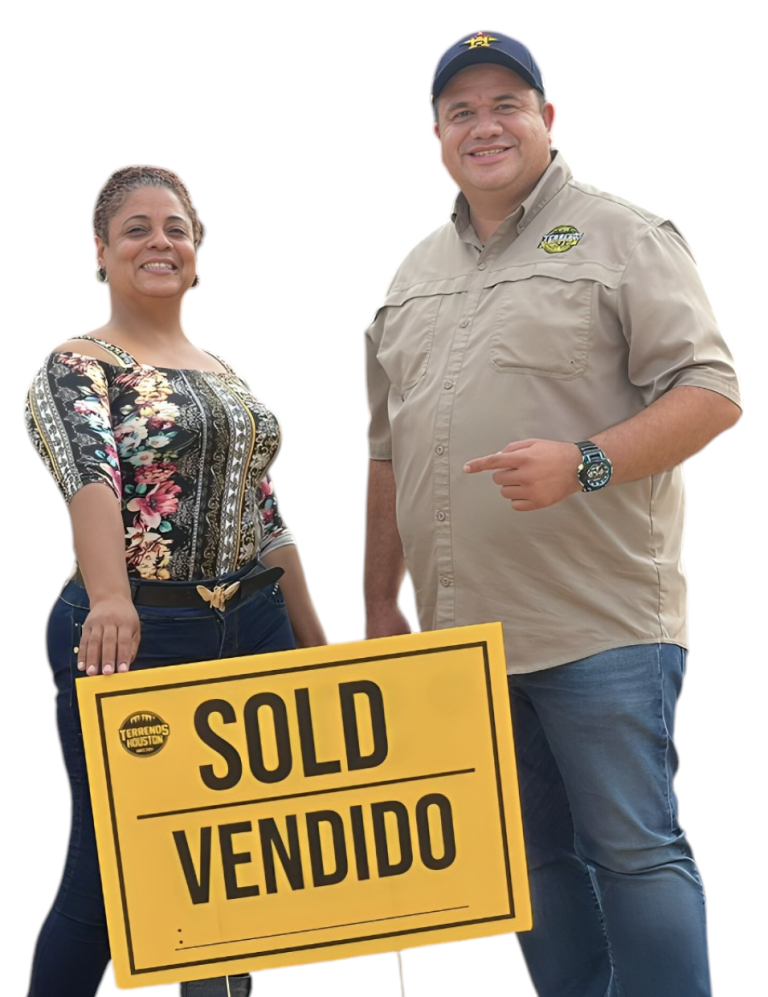 Pareja celebrando con un letrero VENDIDO de Terrenos Houston